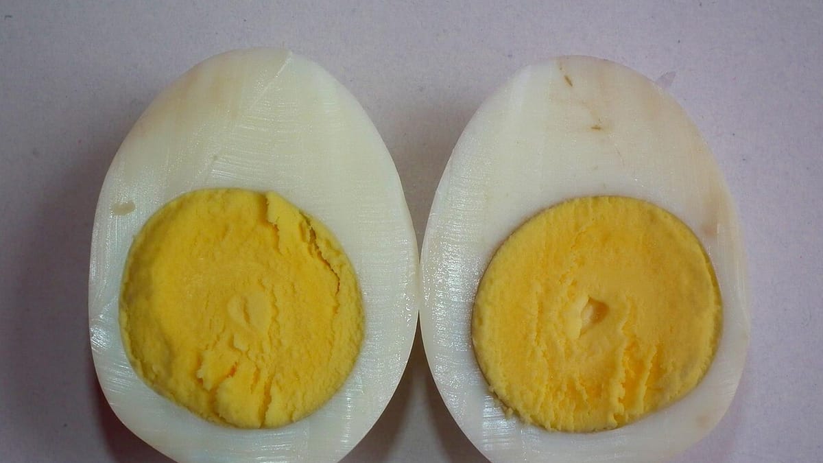 Sebutir telur rebus matang yang dibelah dua memperlihatkan putih telur dan kuning telur yang padat