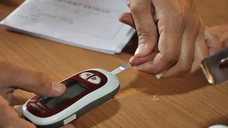 Strip tes pada glukometer ditempelkan ke setetes darah di ujung jari untuk memeriksa kadar gula darah