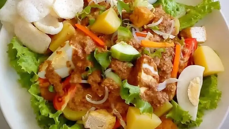 Gado-gado berisi selada, kentang, tahu, telur rebus, mentimun, dan wortel bersiram bumbu kacang dengan kerupuk