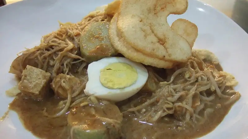 Sepiring ketoprak berisi bihun, tauge, tahu, potongan lontong, setengah telur rebus, dan kerupuk dengan siraman bumbu kacang